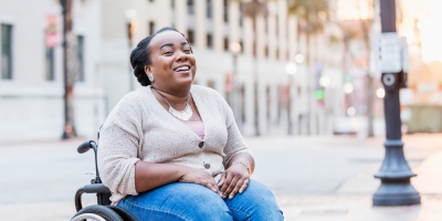 Headline image shows a Black wheelchair user laughing outside.